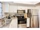 Bright kitchen with white cabinetry and modern stainless steel appliances, designed for convenient meal preparation at 3821 Lake Bayshore Dr # H-507, Bradenton, FL 34205