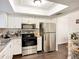 Bright kitchen with white cabinetry and modern stainless steel appliances, designed for convenient meal preparation at 3821 Lake Bayshore Dr # H-507, Bradenton, FL 34205