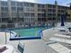 Inviting community pool surrounded by lounge seating with umbrellas at 3821 Lake Bayshore Dr # H-507, Bradenton, FL 34205