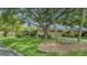 Charming home featuring a lush green lawn with mature trees and a well-maintained landscape at 3842 Glen Oaks Manor Dr, Sarasota, FL 34232