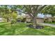 Charming home featuring a lush green lawn with mature trees and a well-maintained landscape at 3842 Glen Oaks Manor Dr, Sarasota, FL 34232