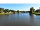 Scenic lake view with lush greenery and homes along the shoreline under a sunny sky at 3842 Glen Oaks Manor Dr, Sarasota, FL 34232