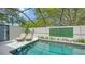Relaxing screened pool with lounge chairs, plants, and privacy wall at 3842 Glen Oaks Manor Dr, Sarasota, FL 34232