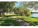 Picturesque community walking path winding through lush greenery towards the tranquil lake at 3842 Glen Oaks Manor Dr, Sarasota, FL 34232