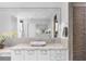 Bathroom with pebble granite vanity, modern lighting, large mirror, and textured accent wall shower at 4765 Gulf Of Mexico Dr # B202, Longboat Key, FL 34228