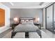 Comfortable bedroom with textured wall, modern lighting, and sleek gray and neutral color scheme at 4765 Gulf Of Mexico Dr # B202, Longboat Key, FL 34228