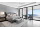 Bright bedroom featuring waterfront views, sliding glass doors, ceiling fan, and elegant gray tones at 4765 Gulf Of Mexico Dr # B202, Longboat Key, FL 34228