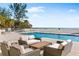 Inviting pool area with comfortable lounge seating and ocean views beyond the beach at 4765 Gulf Of Mexico Dr # B202, Longboat Key, FL 34228