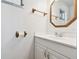 Bathroom showcasing a wooden mirror, towel rack, and white cabinetry at 4803 Brae Burn Ave, Sarasota, FL 34234