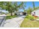 Single-story home featuring a spacious driveway, a mature tree, and well-kept landscaping, providing a serene setting at 4803 Brae Burn Ave, Sarasota, FL 34234