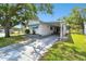 Single-story home featuring a spacious driveway and mature tree, and manicured landscaping, providing a serene setting at 4803 Brae Burn Ave, Sarasota, FL 34234