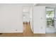 Hallway showing durable wood flooring, leading to a living room, and the exterior patio at 4803 Brae Burn Ave, Sarasota, FL 34234