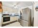 Galley kitchen features stainless steel refrigerator and range with ample cabinet space at 4803 Brae Burn Ave, Sarasota, FL 34234