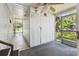 Enclosed porch featuring durable carpet, bright lighting, and a convenient storage closet at 4803 Brae Burn Ave, Sarasota, FL 34234