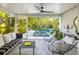 Relaxing sunroom with stylish seating and tranquil views of the sparkling pool and lush greenery at 494 Sapphire Dr, Sarasota, FL 34234