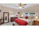 Bright bedroom with large windows, ceiling fan, and a comfortable bed dressed with decorative pillows and a red throw at 504 Whitfield Ave, Sarasota, FL 34243
