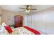 Inviting bedroom featuring a ceiling fan, closet, and a bed dressed in a floral comforter with red accents at 504 Whitfield Ave, Sarasota, FL 34243
