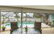 Outdoor patio area with seating and views of the screened-in pool and backyard at 504 Whitfield Ave, Sarasota, FL 34243