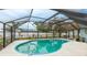 Screened in pool featuring clear blue water surrounded by a white concrete deck and lush tropical landscaping beyond the enclosure at 504 Whitfield Ave, Sarasota, FL 34243
