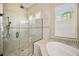 Modern bathroom with a glass-enclosed shower and separate soaking tub with natural light at 5313 Greenbrook Dr, Sarasota, FL 34238