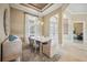 Dining room with neutral tones, modern chandelier, and adjacent view of the living area, showcasing an open floor plan at 5313 Greenbrook Dr, Sarasota, FL 34238