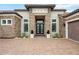 Close-up view of home showcasing stone accents, a tile roof, brick driveway, and manicured landscaping that create curb appeal at 5313 Greenbrook Dr, Sarasota, FL 34238