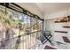 Cozy screened balcony with tile flooring, grill, and a serene view of the surrounding greenery at 5500 Longwood Run Blvd # 201, Sarasota, FL 34243
