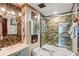 Bathroom featuring an ornate vanity, stone tile, and shower tub at 5500 Longwood Run Blvd # 201, Sarasota, FL 34243