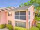 Rear exterior featuring screened balcony, well maintained stucco and mature surrounding landscaping at 5500 Longwood Run Blvd # 201, Sarasota, FL 34243
