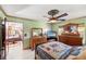 Well-lit bedroom features a decorated ceiling fan, tile floors, and wood furniture at 5500 Longwood Run Blvd # 201, Sarasota, FL 34243