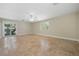 Open living room with neutral walls, travertine tile floors, a ceiling fan, and access to a small balcony at 5512 Avenida Del Mare, Sarasota, FL 34242