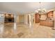 Open-concept living room with stone fireplace, travertine tile, and seamless transition to the eat-in kitchen at 5512 Avenida Del Mare, Sarasota, FL 34242