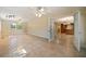 Large open living room with multiple ceiling fans, travertine floors, and a doorway leading into another living space at 5512 Avenida Del Mare, Sarasota, FL 34242