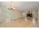 Open living room showcasing stone fireplace, with travertine floors, chandelier, and views into another room with ceiling fans at 5512 Avenida Del Mare, Sarasota, FL 34242
