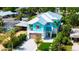 Aerial view of a home with a well-manicured yard, striking blue facade, and a metal roof at 5930 Briarwood Ave, Sarasota, FL 34231