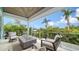 Spacious balcony with seating and a modern fire pit overlooking lush greenery and blue skies at 5930 Briarwood Ave, Sarasota, FL 34231