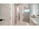 Well-lit bathroom showcasing a glass shower and vanity area with white marble countertops at 5930 Briarwood Ave, Sarasota, FL 34231