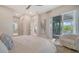 Airy bedroom featuring a private balcony, neutral decor, and an attached bathroom at 5930 Briarwood Ave, Sarasota, FL 34231