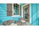 Charming front porch with light blue siding and wood trim, seating area, and decorative window at 5930 Briarwood Ave, Sarasota, FL 34231