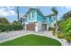 Charming light blue two-story home with a paver driveway, lush landscaping, and a garage at 5930 Briarwood Ave, Sarasota, FL 34231