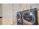 Laundry room featuring a modern washer and dryer with a gray finish at 5930 Briarwood Ave, Sarasota, FL 34231