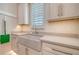 Bright laundry room featuring a deep sink, white cabinets, and sleek countertops at 5930 Briarwood Ave, Sarasota, FL 34231