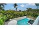 Aerial view of the backyard pool, spa, and lush tropical foliage, creating a private oasis for relaxation at 5930 Briarwood Ave, Sarasota, FL 34231