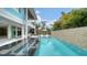 A beautiful pool in a backyard with an open floor plan with lounge chairs and sun umbrellas at 5930 Briarwood Ave, Sarasota, FL 34231