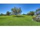 Expansive backyard with lush green grass and mature trees, offering a serene and private outdoor space at 626 Magellan Dr, Sarasota, FL 34243