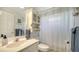 This bathroom includes a sink, toilet, shower with curtain, and overhead storage at 626 Magellan Dr, Sarasota, FL 34243