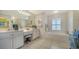 Bright bathroom with dual sinks, vanity area, soaking tub, and white tile flooring at 626 Magellan Dr, Sarasota, FL 34243