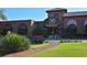 Elegant clubhouse entrance with manicured lawn, brick path and covered portico at 626 Magellan Dr, Sarasota, FL 34243