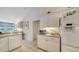Bright kitchen with white cabinets, grey countertops, stainless steel appliances, and tile floors at 626 Magellan Dr, Sarasota, FL 34243