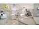 Modern kitchen with bright white cabinets, tile backsplash, stainless appliances, and a view of the dining area at 626 Magellan Dr, Sarasota, FL 34243